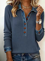 Woman wearing a blue ribbed sweater with button details against a neutral background