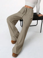 Striped pants worn by a person sitting on a chair with a white background