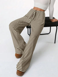 Striped pants worn by a person sitting on a chair with a white background