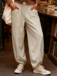 Person wearing beige pants and Converse shoes in a bookstore setting
