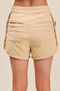 Beige shorts worn by a person on a beige background