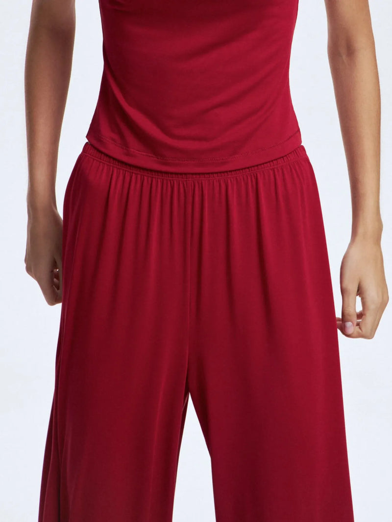 Red outfit with a top and wide-leg pants on a white background