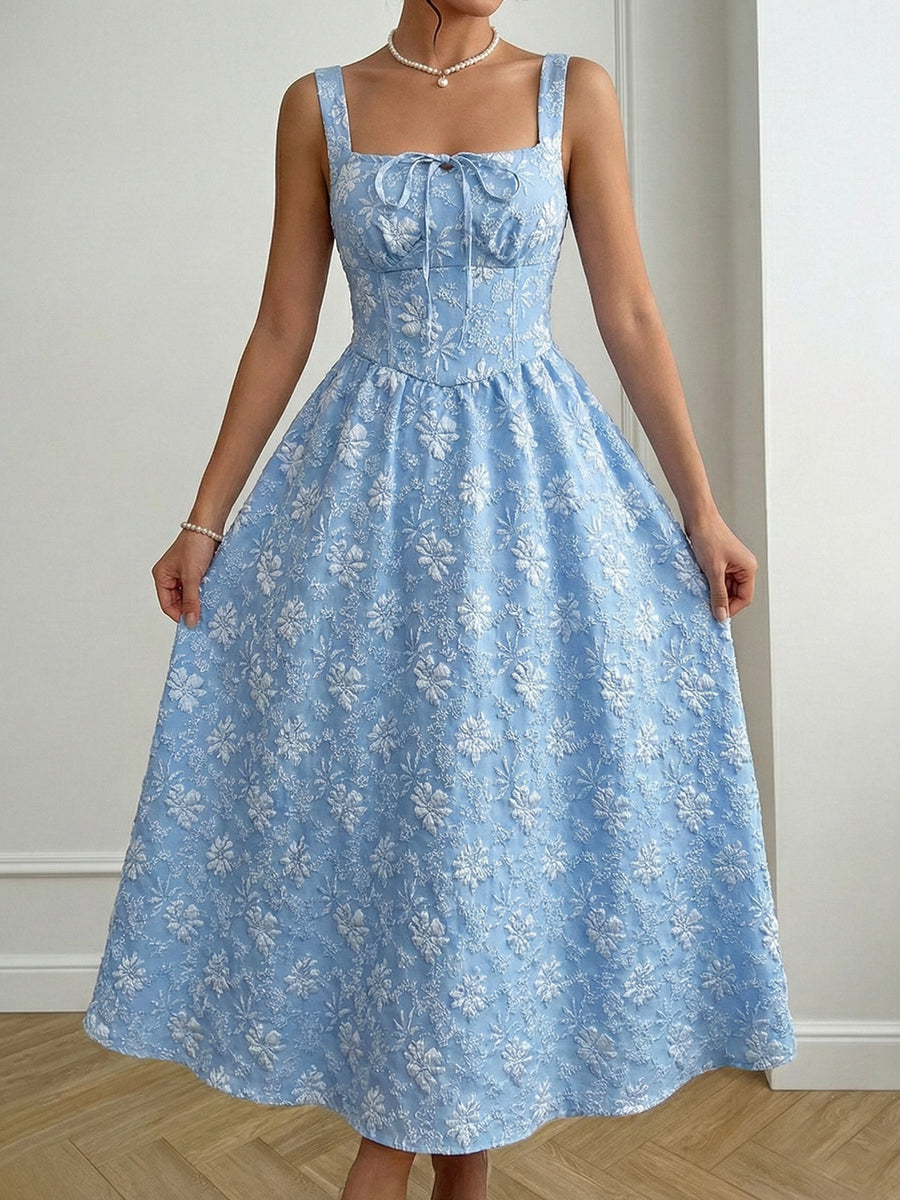 Woman wearing a blue floral dress against a plain background