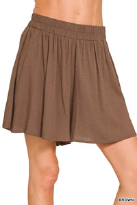 Brown skirt worn by a person on a white background
