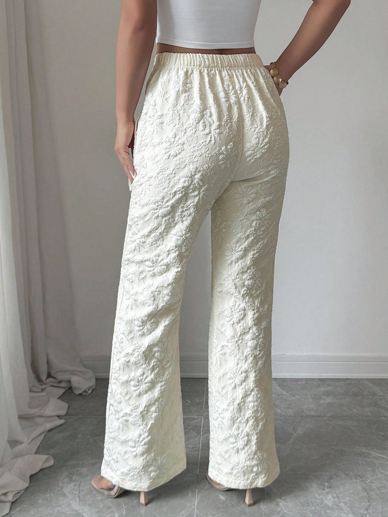 Person wearing textured white pants against a neutral background