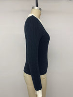 A dark navy blue cable-knit sweater with a contrasting white collar, cuffs, and hem, displayed on a beige mannequin torso against a plain light gray background.