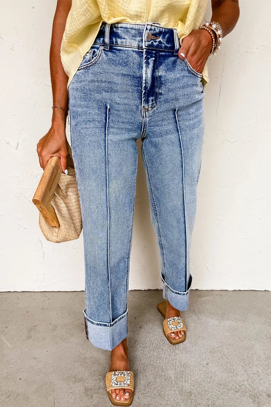 Person wearing blue jeans with a plain background