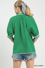 Woman wearing a green blouse with puffed sleeves on a white background