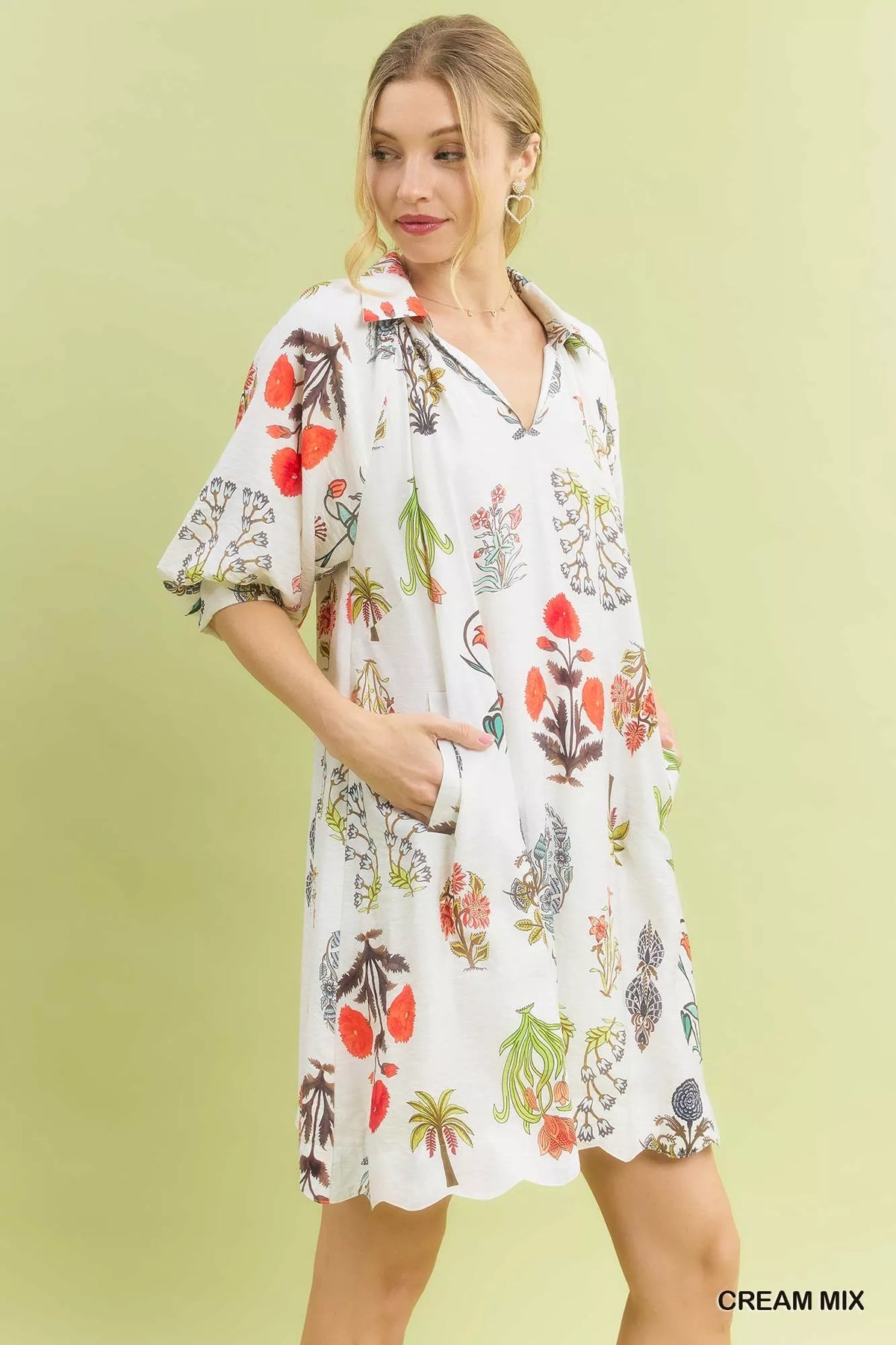 Woman wearing a floral dress against a light green background