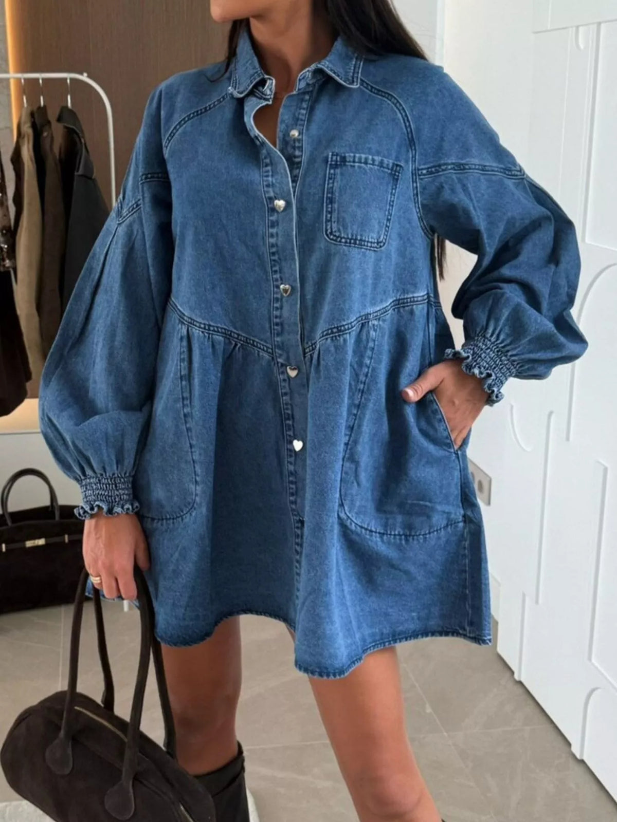 Person wearing a blue denim dress in an indoor setting