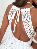 White crochet halter top worn by a person on a white background