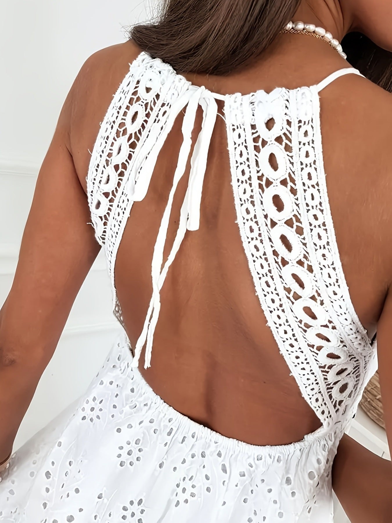 White crochet halter top worn by a person on a white background