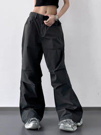 Person wearing black wide-leg pants on a plain background