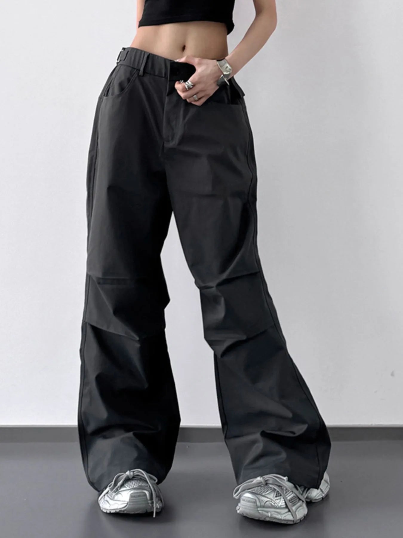 Person wearing black wide-leg pants on a plain background