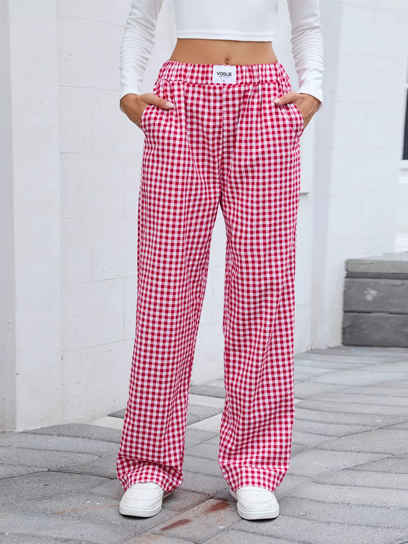Red and white checkered pants worn by a person on a gray pavement.