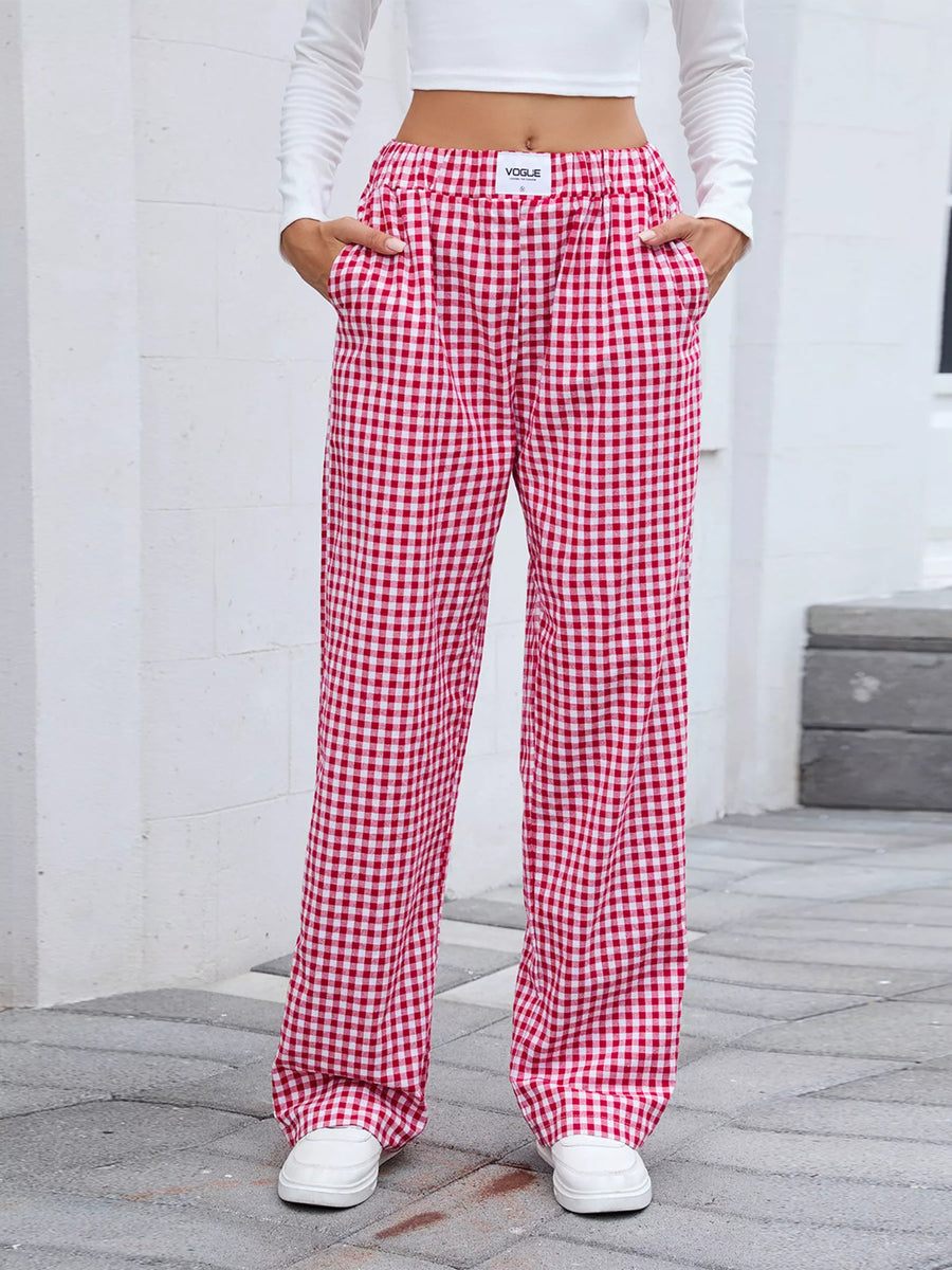 Red and white checkered pants worn by a person on a gray pavement.