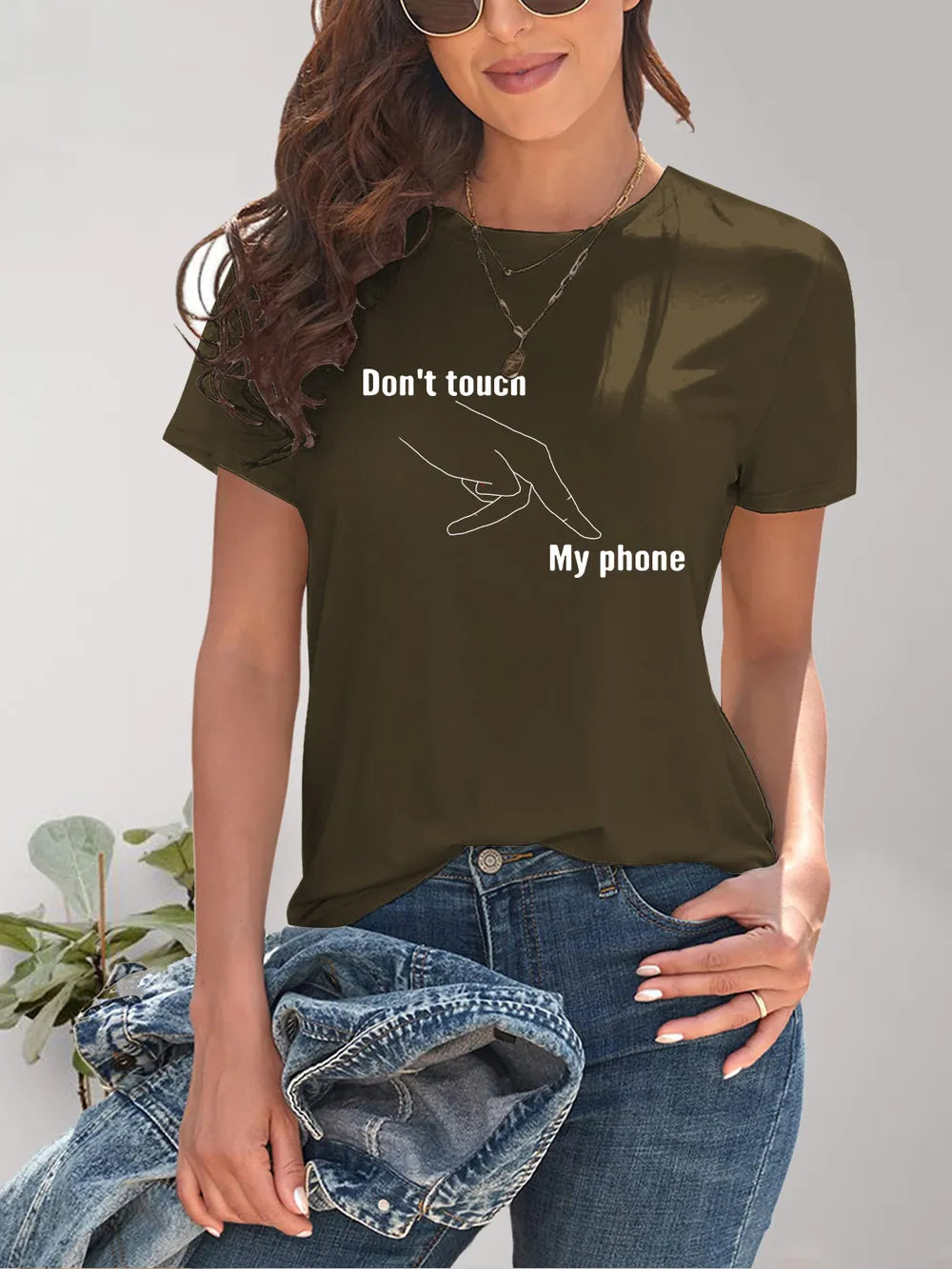 Person wearing a brown t-shirt with 'Don't touch my phone' text and graphic.