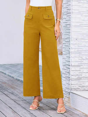 Mustard yellow pants worn by a person on a wooden deck.