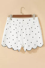 White shorts with black polka dots on a beige background