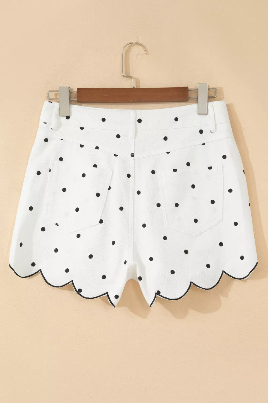 White shorts with black polka dots on a beige background