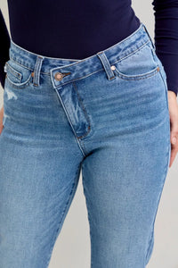 Blue jeans worn by a person on a gray background