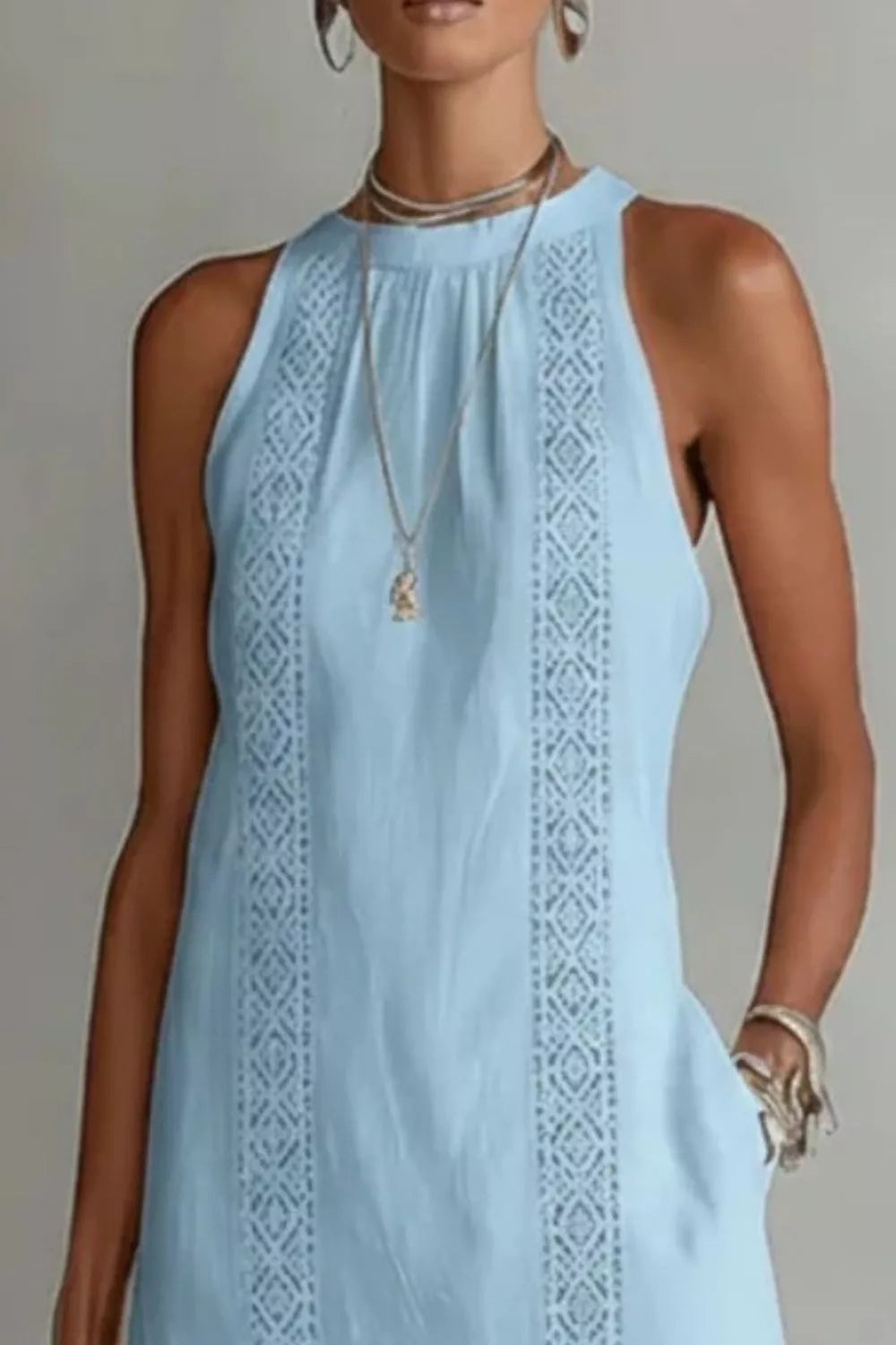 Light blue sleeveless dress with intricate patterns on a neutral background