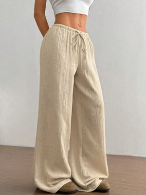 Beige wide-leg pants worn by a person on a plain background