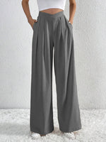 Person wearing gray wide-leg pants against a white background