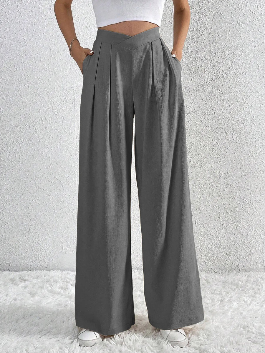 Person wearing gray wide-leg pants against a white background