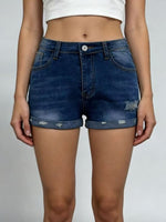 Person wearing blue denim shorts on a plain background