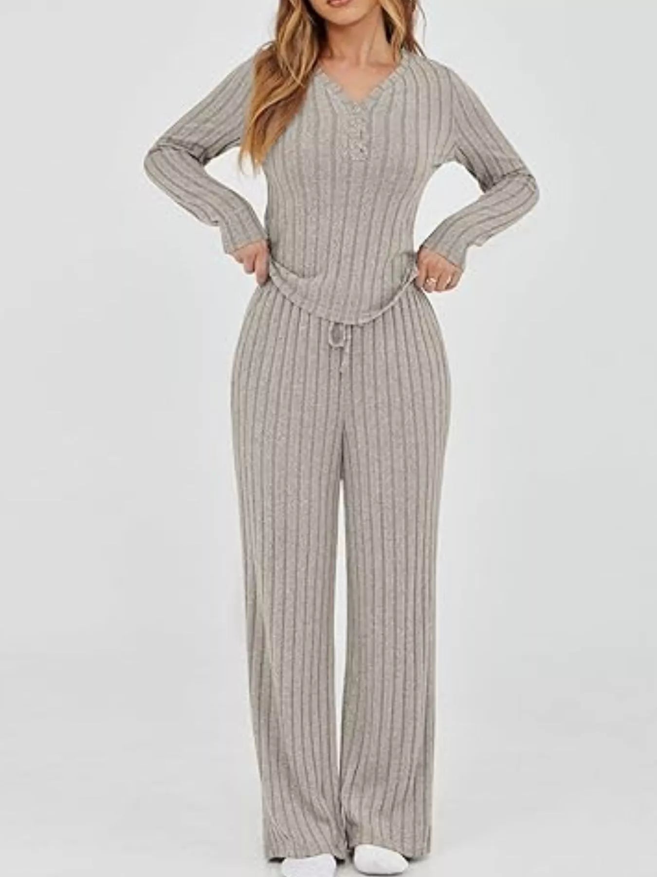 Woman wearing a ribbed knit jumpsuit on a white background
