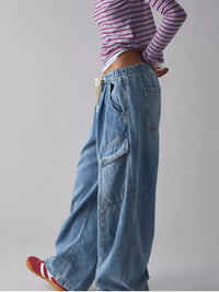 Person wearing wide-leg jeans and a striped shirt on a plain background