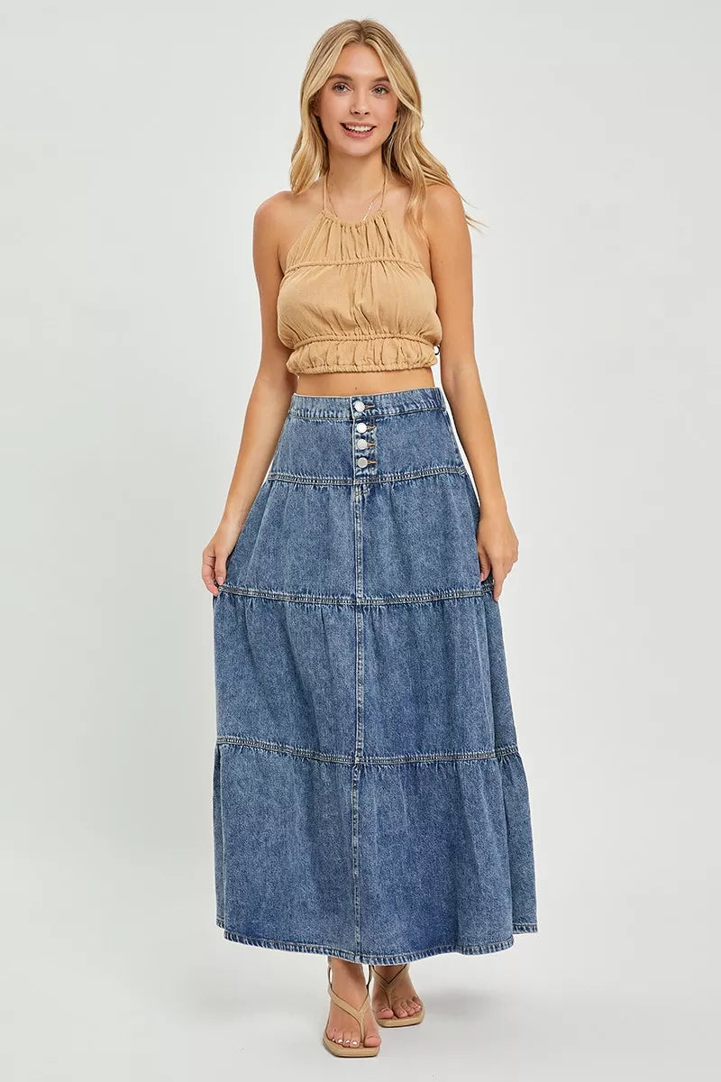 Woman wearing a beige top and denim skirt on a white background