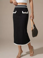Person wearing a black skirt with white trim on a beige background