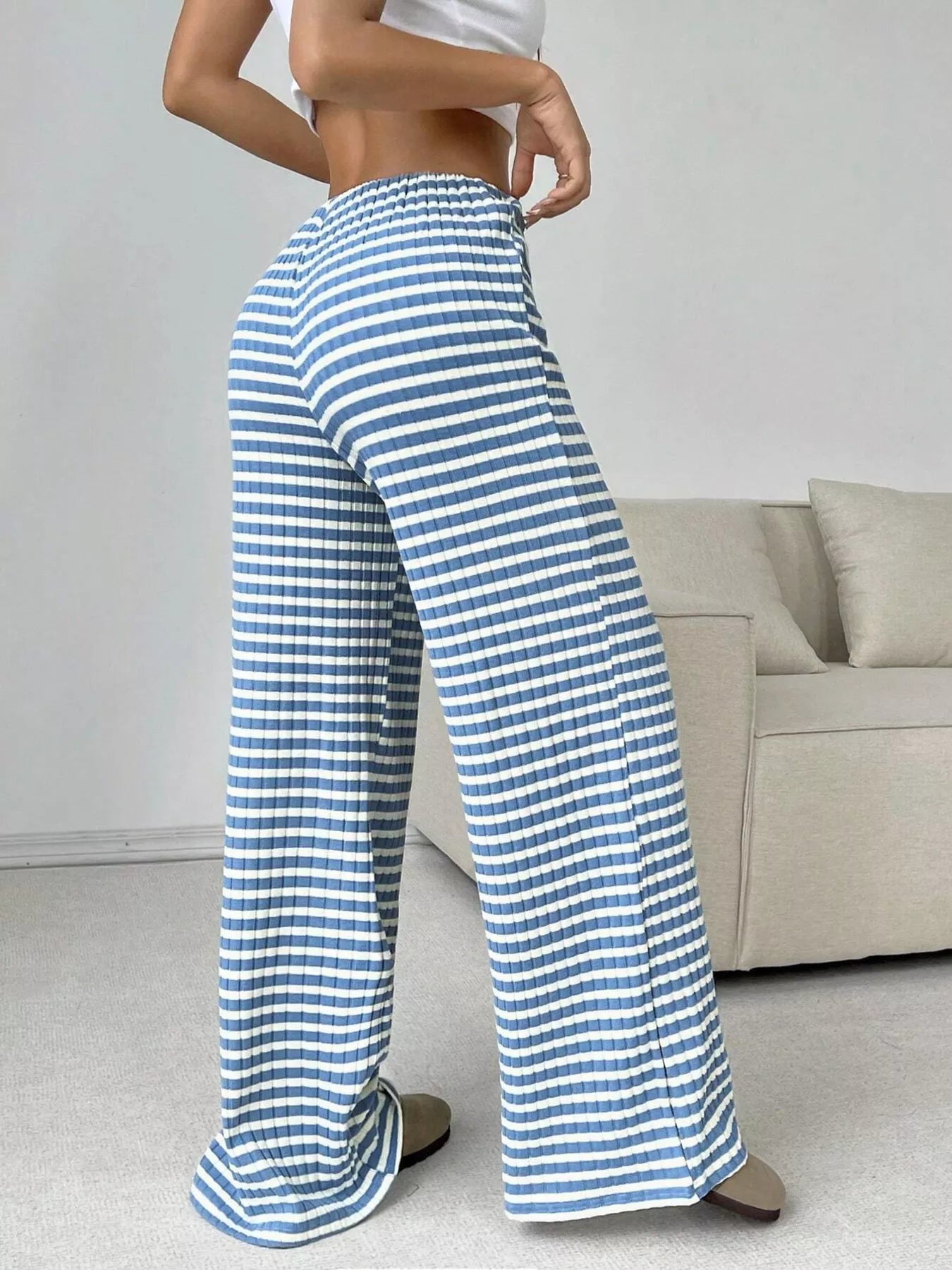 Person wearing blue and white striped pants in a living room setting