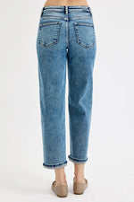 Blue jeans worn by a person on a white background