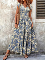 Woman wearing a floral dress standing against a textured wall.