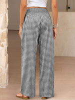 Person wearing black and white checkered pants indoors.