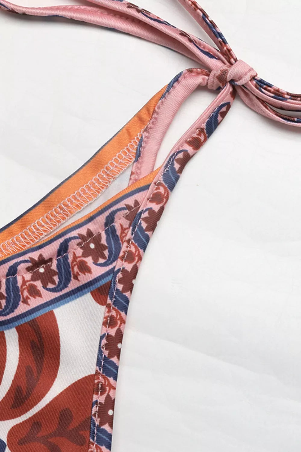 Colorful patterned bikini strap on a white background