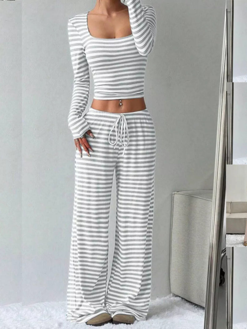 Person wearing a gray and white striped outfit with a plain background