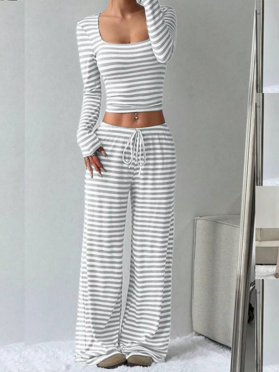 Person wearing a gray and white striped outfit with a plain background