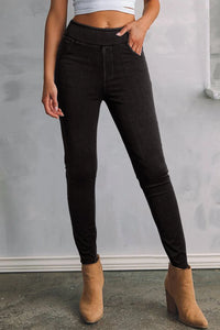 Person wearing black jeans and tan boots against a gray background