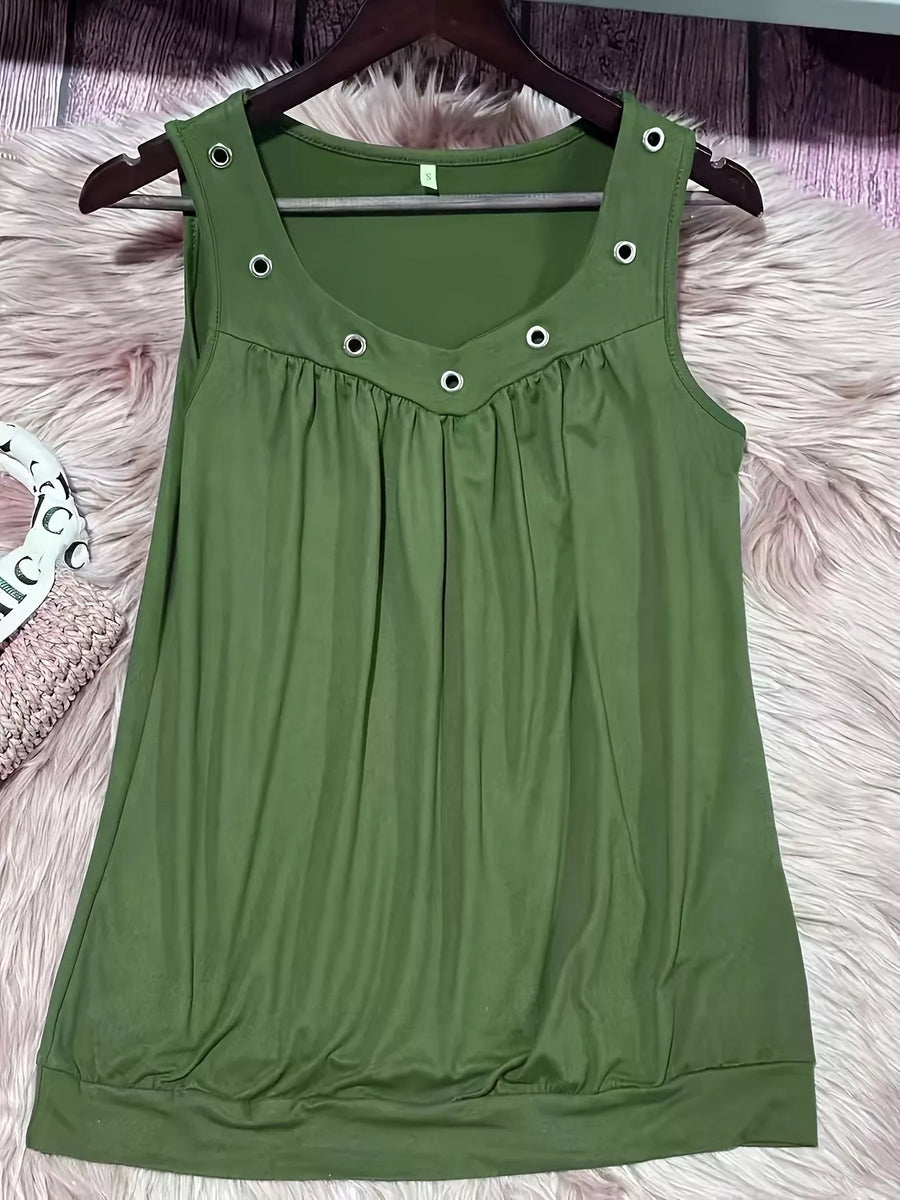 Green sleeveless dress with button details on a hanger against a fluffy pink surface.