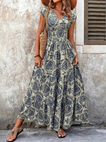 Woman wearing a floral dress standing against a textured wall.