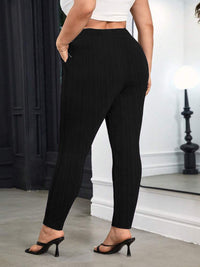 Person wearing black pants and a white top in an indoor setting