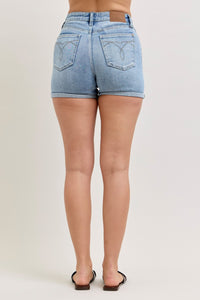 Light blue denim shorts worn by a person on a plain background