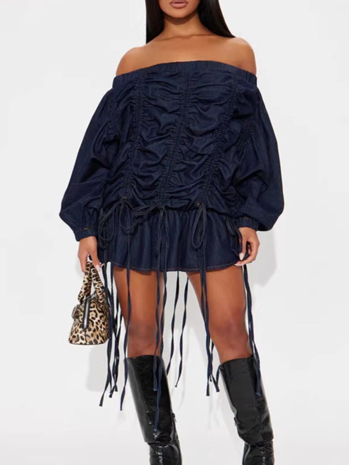 Navy off-shoulder dress with fringes and black knee-high boots on a white background