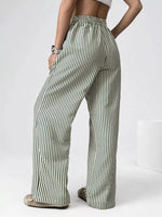 Person wearing green and white striped pants on a white background