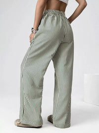 Person wearing green and white striped pants on a white background