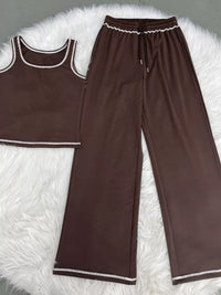 Brown tank top and wide-leg pants set on a white fluffy surface